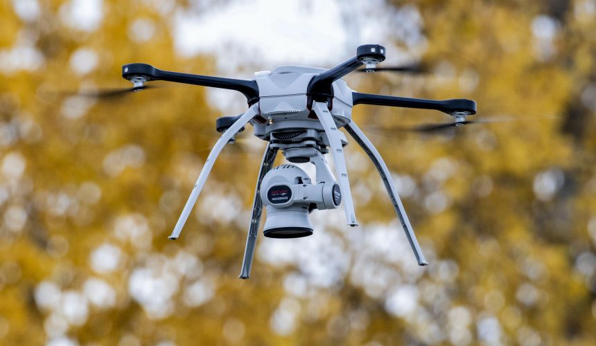 Silueta de un dron militar pequeño sobre un paisaje de frente de guerra; concepto de conflicto contemporáneo entre Ucrania y Rusia
